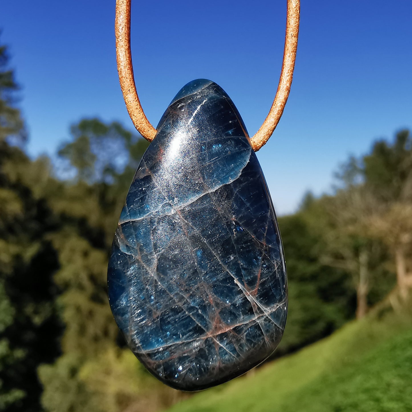 Drilled apatite pendant including leather strap