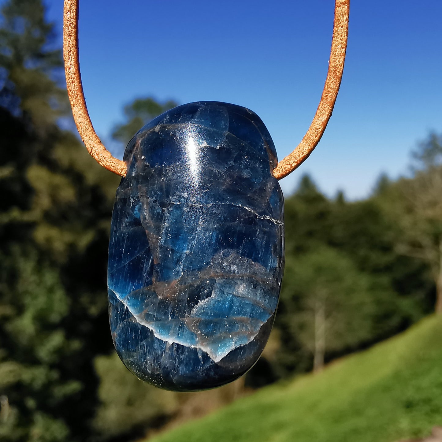 Drilled apatite pendant including leather strap